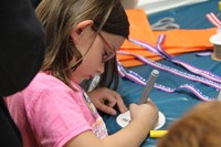 girl coloring in olympic medal