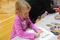 girl coloring in thank you to veterans page