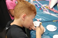 boy coloring in olympic medal at humanities night