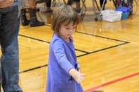 little girl throwing a ball as part of humanities night game