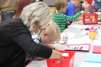 parent helping student to color at humanities night