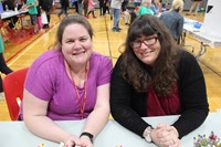 two c v staff members at welcoming table at humanities night