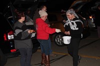 people handing out candy for trunk or treat event