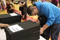 student sticking hand into box of fake monster brains