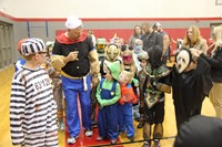 students in parade with mister krause at halloween event