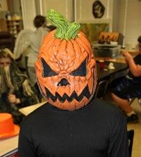 student dressed in spooky pumpkin head costume