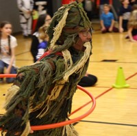 student dressed as grass monster hula hooping