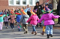 pre school students walking with scarecrow hats they made on