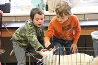 two boys pet goat