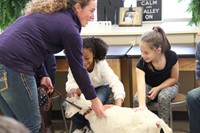 two girls pet captain the goat