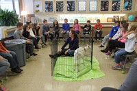 students talk to miss atwood while she sits in play pen near goat