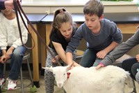 two students pet goat