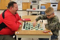 student and teacher playing chess