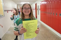 student smiling with scavenger hunt paper