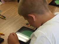 boy summer steam student looks at iPAd to learn about colors