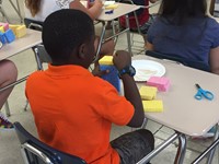 up close of boy summer steam student working on sprout house