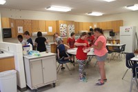 wide shot of students and teachers making pancakes as part of c v summer steam program lesson