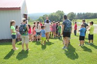 owner talks with students and staff outside of cow barn