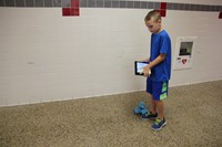 boy controls dash robot using ipad in hallway