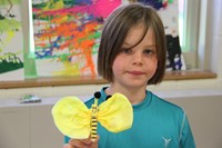 girl smiles with her bee artwork