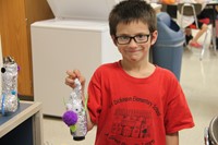 boy smiles with recycled robot project