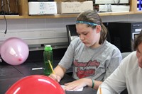 c v student writes her equation in boces summer steam academy project.