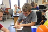 c v student writes out equation at boces summer steam academy