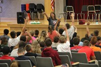 students raise their hands to participate in musical chairs at freshman orientation