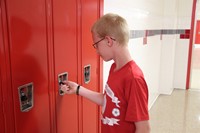 student opening his locker at freshman orientation