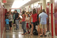 wide shot of sixth grade students opening their new lockers at sixth grade orientation