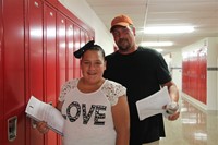 student and parent standing near her new locker at middle school orientation