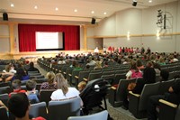 far away shot of principal attleson speaking with sixth grade students parents and guardians in audi