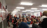wide shot of sixth grade students parents and guardians in middle school cafeteria at middle school 