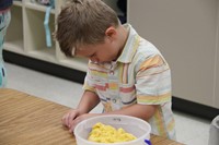 boy builds shapes with yellow clay