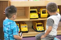 boys look at toy school buses
