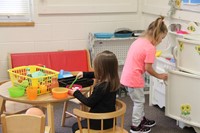 pre k students play in toy kitchen