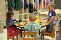 three pre k students play with blocks on first day
