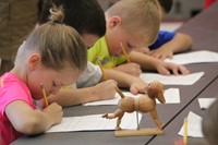 students sketch wooden dog