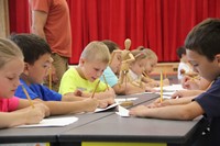 students work to sketch wooden figure for sketching lesson