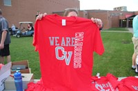 person holds up example of red rally in the valley tee shirt