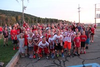 students jump in excitement yelling go warriors for large group photo at rally in the valley