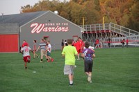 students playing in the field by the warrior stadium at rally in the valley