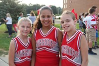 three warrior cheerleaders smile