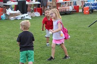 young children dance to music on the grass