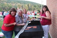 c v staff members smile as they work to grill up hot dogs for rally in the valley event