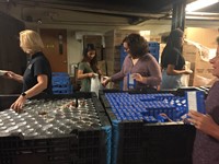 c v teacher anne marie griffin helps to fill bag with mac and cheese box for food bank backpack prog