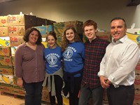 interact club officers smile in front of filled boxes with c v teacher anne marie griffin and superi