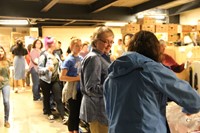 line of people helping to fill bags of food for backpack program