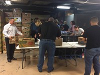 superintendent david gill helps to load boxes for food bank back pack program