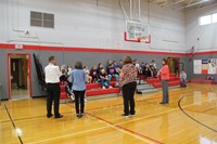 far shot of c v staff talking to students in middle school gymnasium